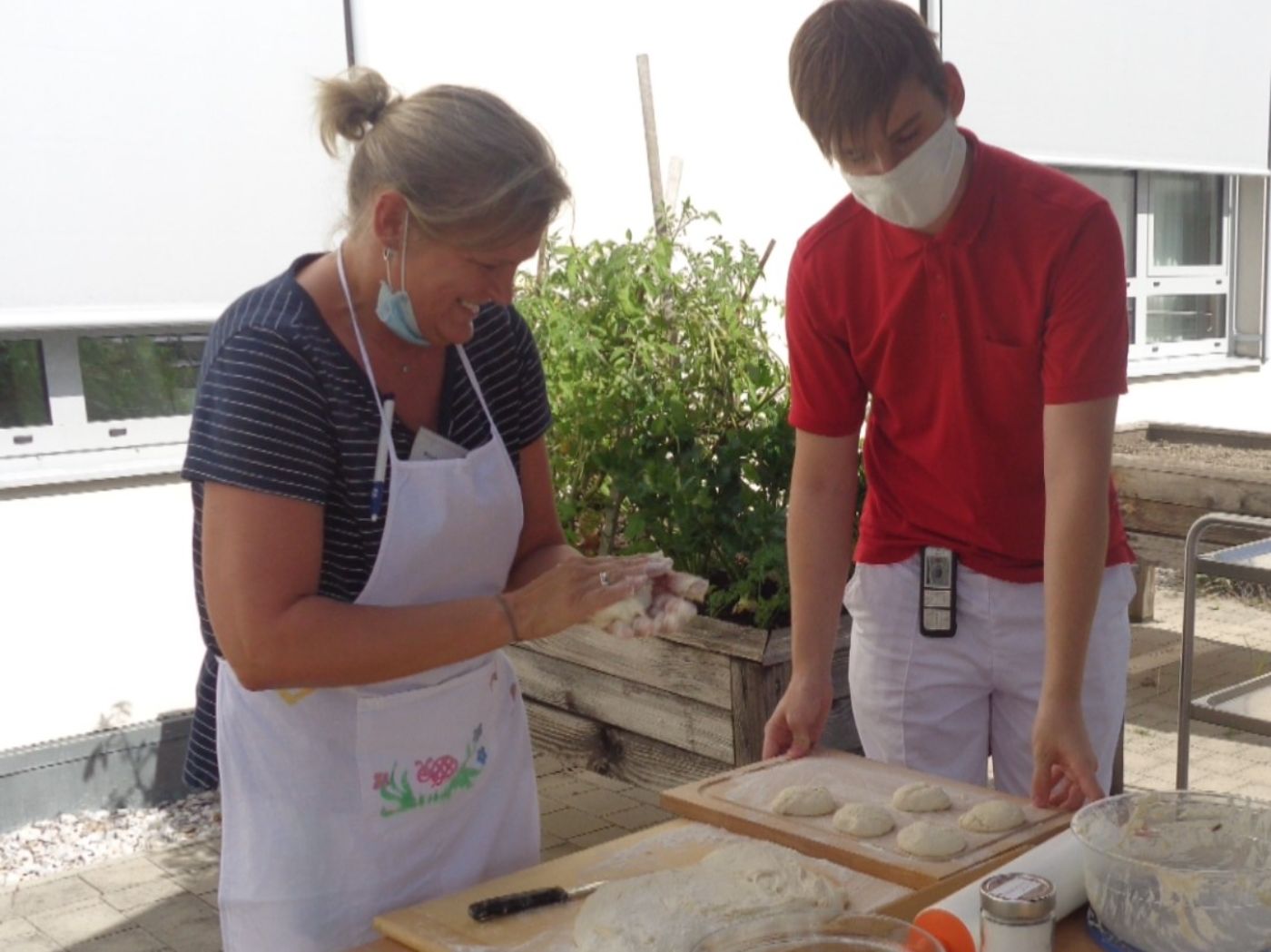 Ein Zivildiener und seine Vorgesetzte beim gemeinsamen Kochen im Freien im Hof der Einrichtung Pflegeheim Oberpullendorf, St. Peter. Die Vorgesetzte trägt eine Schürze.