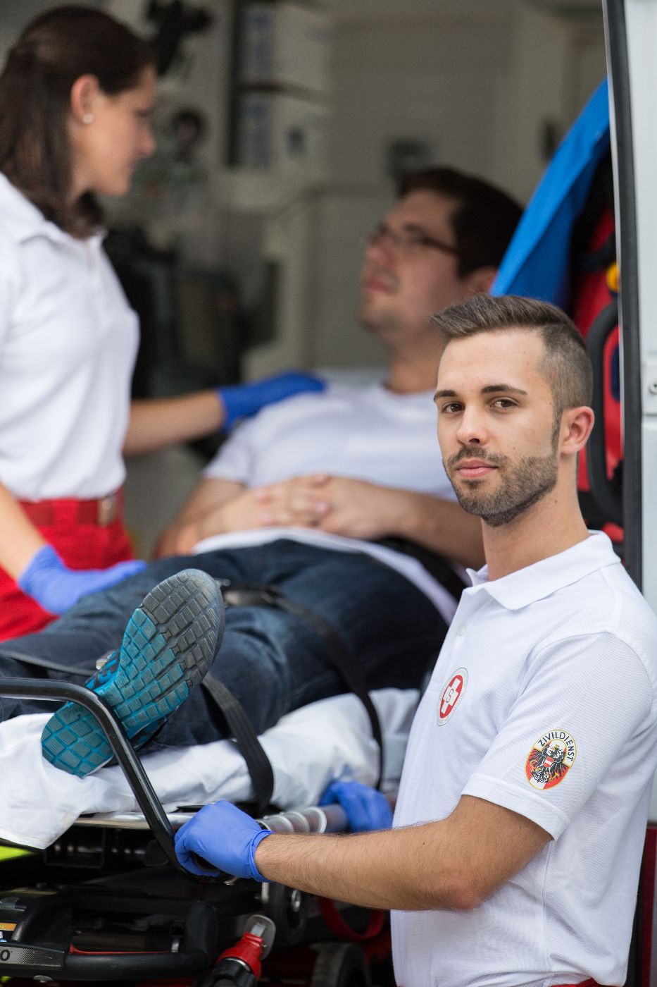 Ein Zivildiener und eine Sanitäterin des Arbeiter-Samariter-Bundes Österreichs betreuen eine Person in einem Krankenwagen