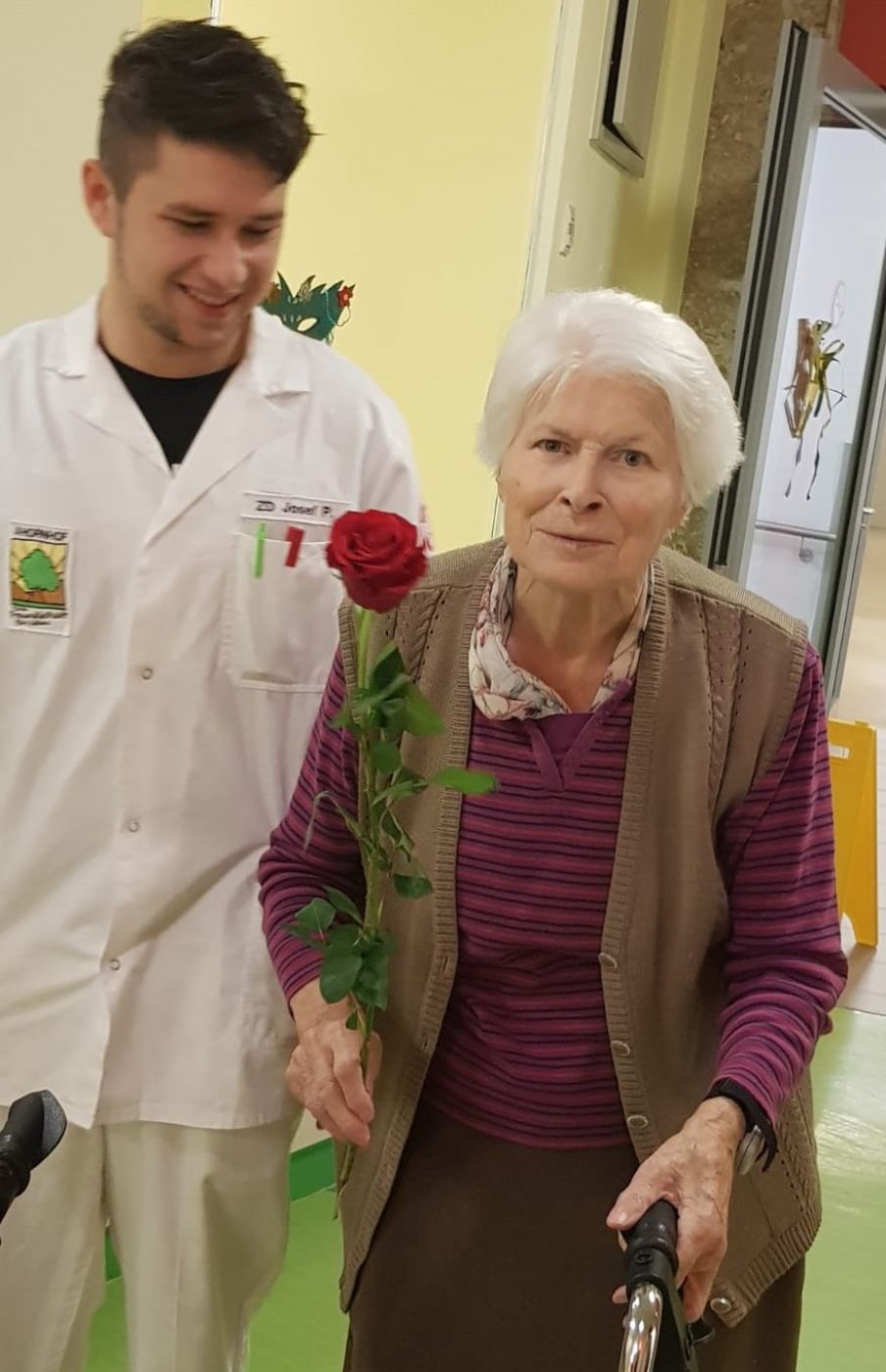 Ein Zivildiener und eine ältere Dame mit einer Blume in den Händen im Seniorenkompetenzzentrum Ahornhof