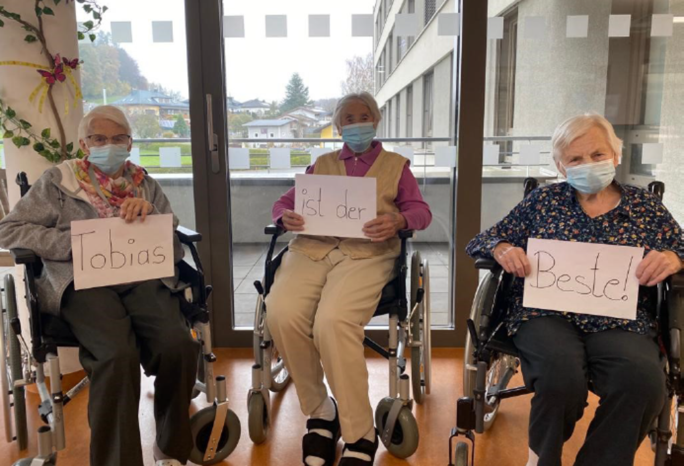 Drei Seniorinnen halten Schilder in den Händen mit der Aufschrift "Tobias ist der Beste".