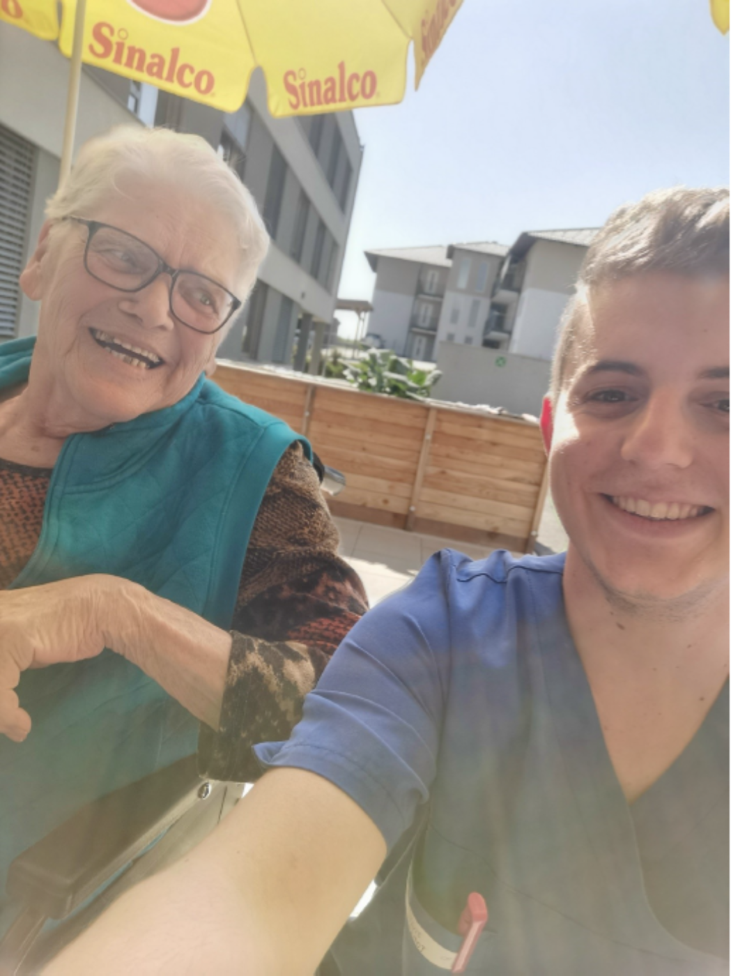 Ein Zivildiener und eine ältere Dame des Bezirksseniorenzentrums Eggelsberg sitzen im Freien bei Sonnenschein