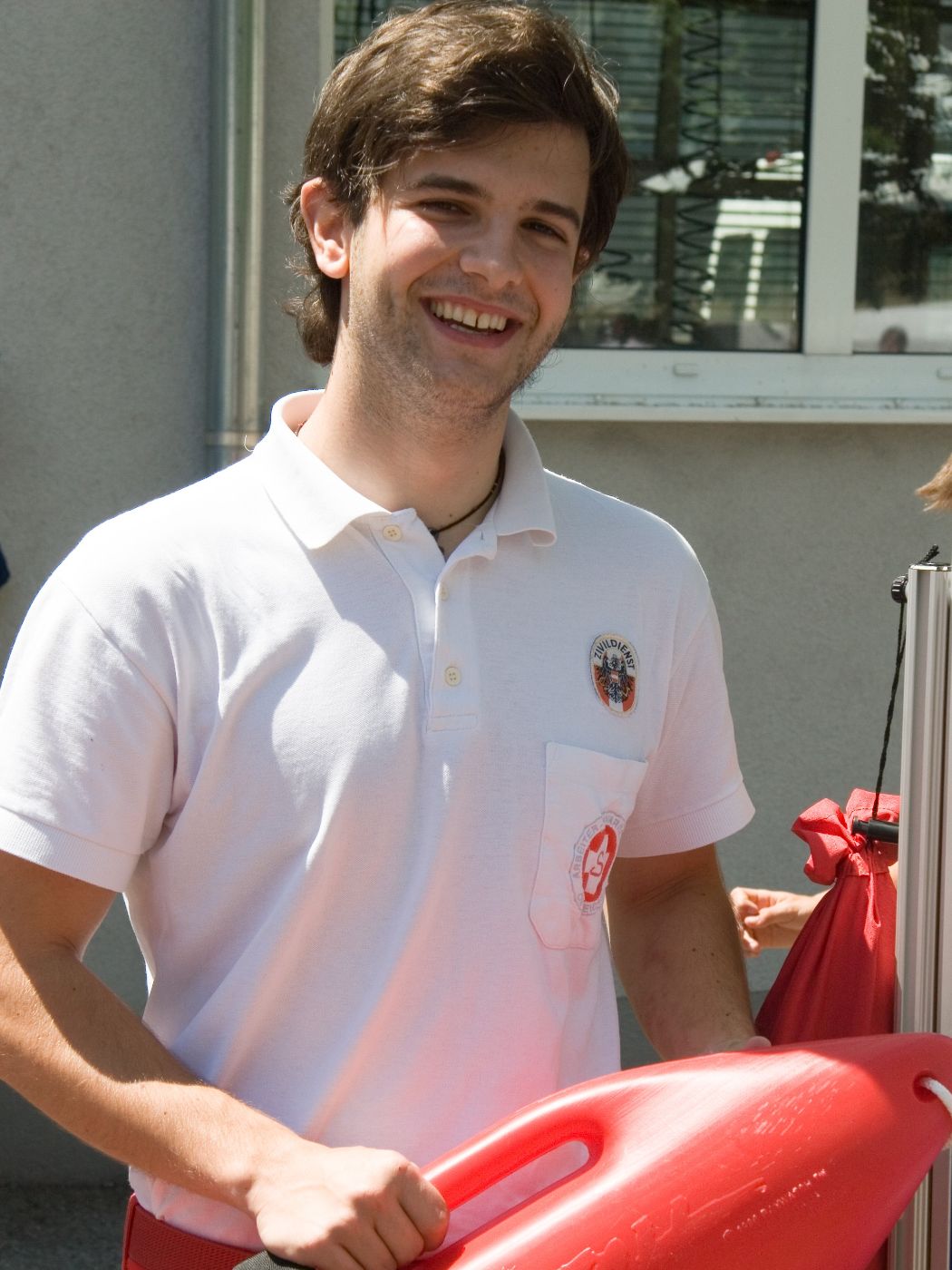 Ein Zivildiener hält eine rote Rettungsboje in den Händen