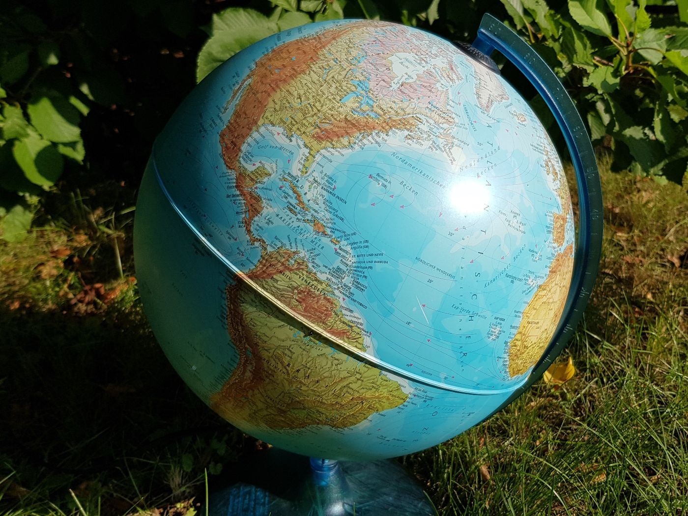 Ein Globus steht auf grünem Gras;